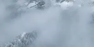 Paisaje nevado con niebla espesa, simbolizando las condiciones meteorológicas adversas durante el rescate de un grupo de jóvenes atrapados en la montaña de Sierra Nevada..
